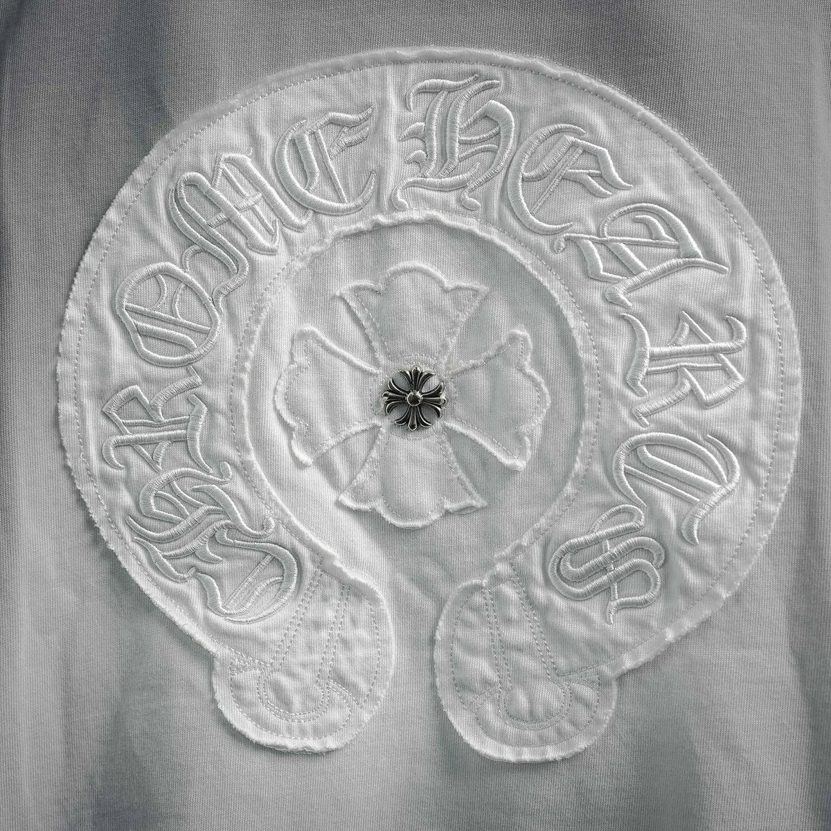 Close-up of circular embroidery with floral center and raised stitches