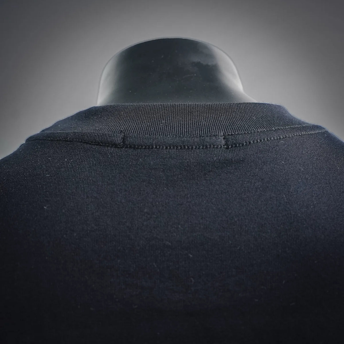 Black crew-neck T-shirt collar seam, no visible front graphics