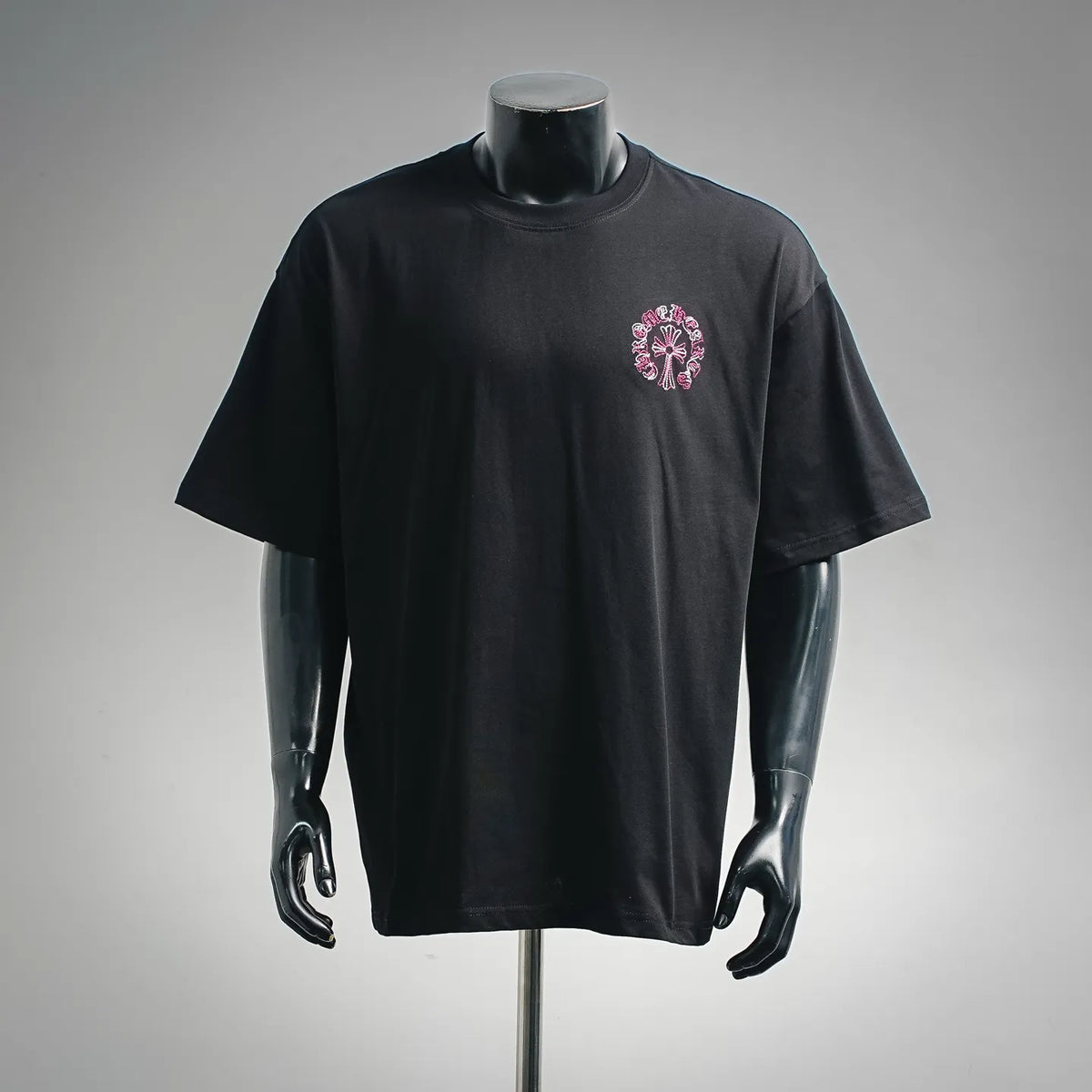 Black short-sleeve T-shirt with small pink-and-white chest graphic