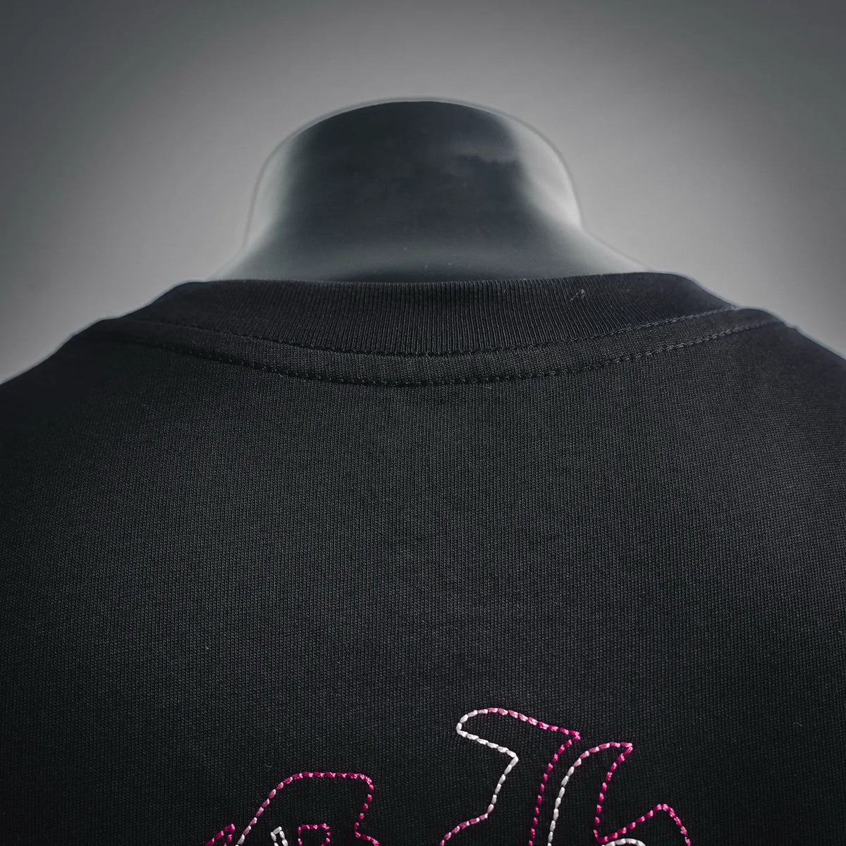 Black T-shirt back neckline with pink-and-white embroidered-style graphic