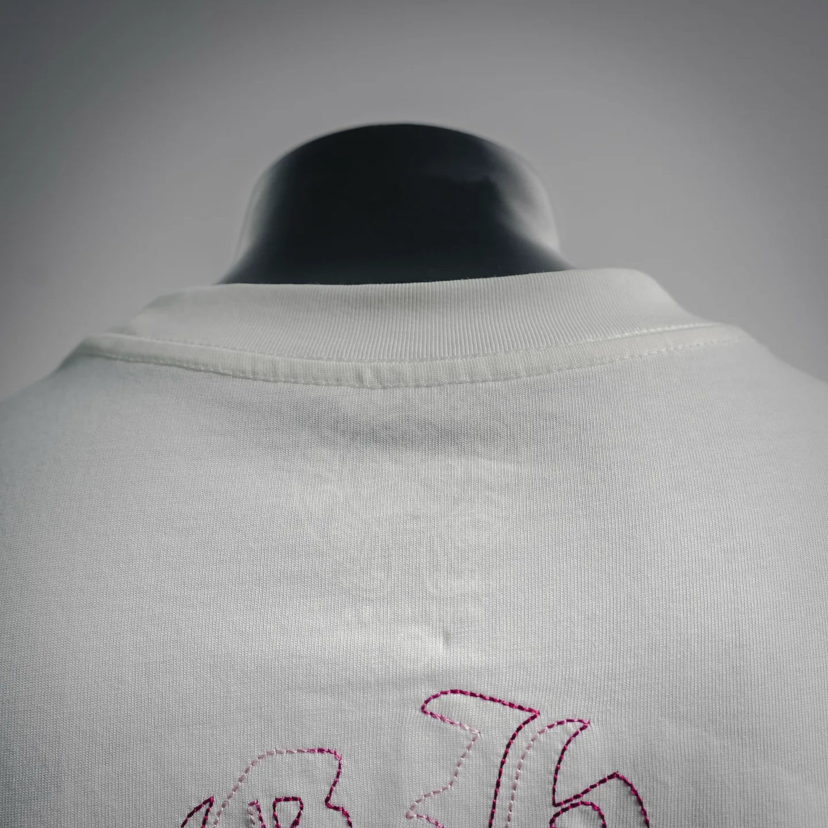 White T-shirt back neckline detail with ribbed collar and top edge embroidery