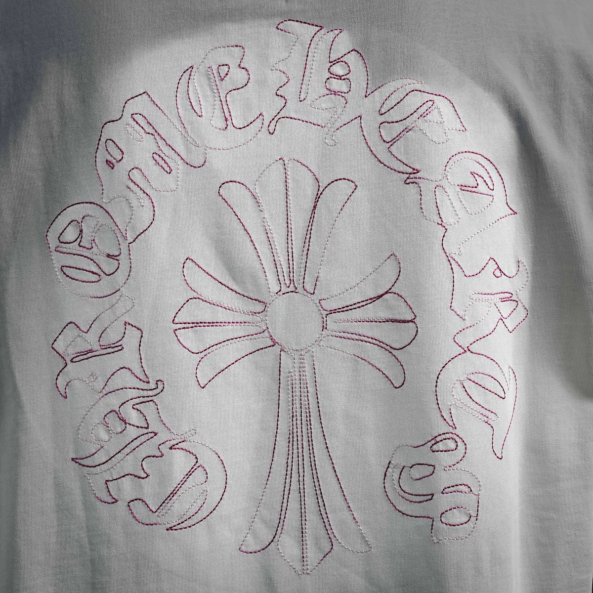 White T-shirt back with outlined pink cross-shaped embroidery and petal pattern
