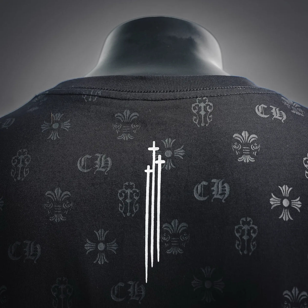 Men's black T-shirt back close-up with vertical sword-style emblem