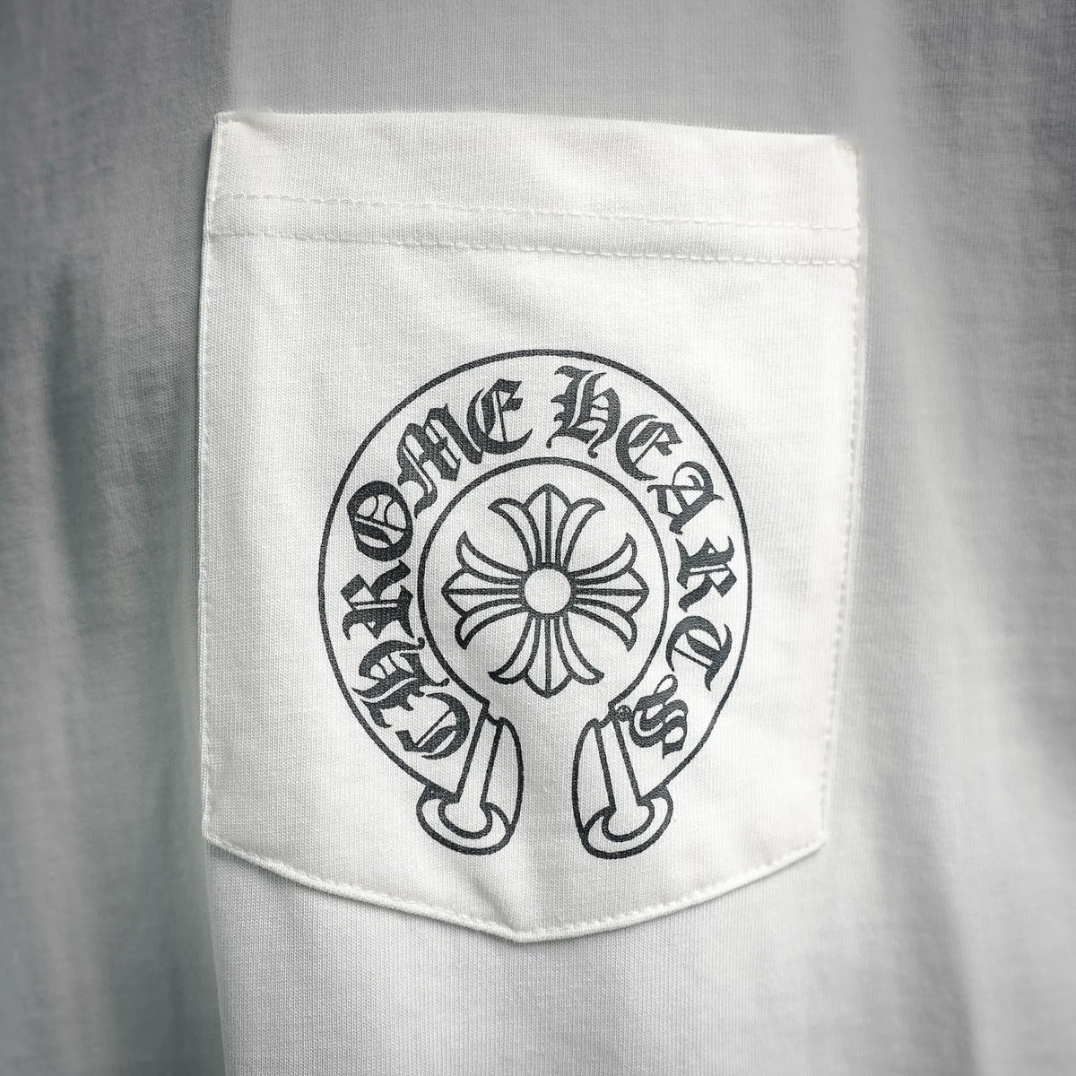 White T-shirt chest pocket with circular logo graphic