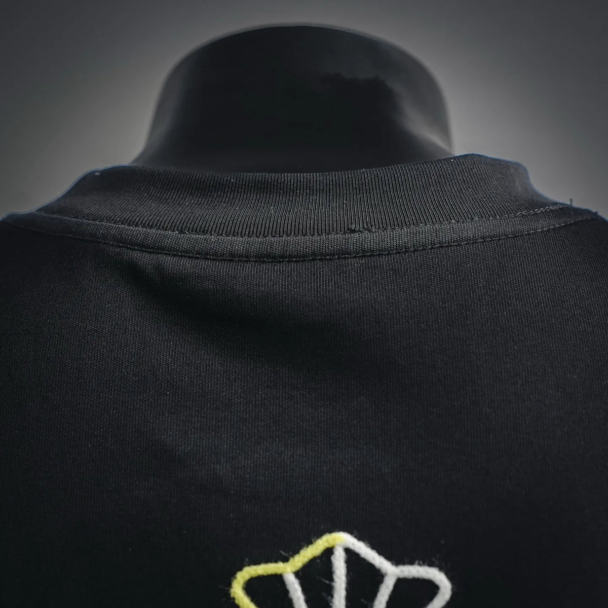 Black crewneck collar with ribbed neckline detail on embroidered T-shirt