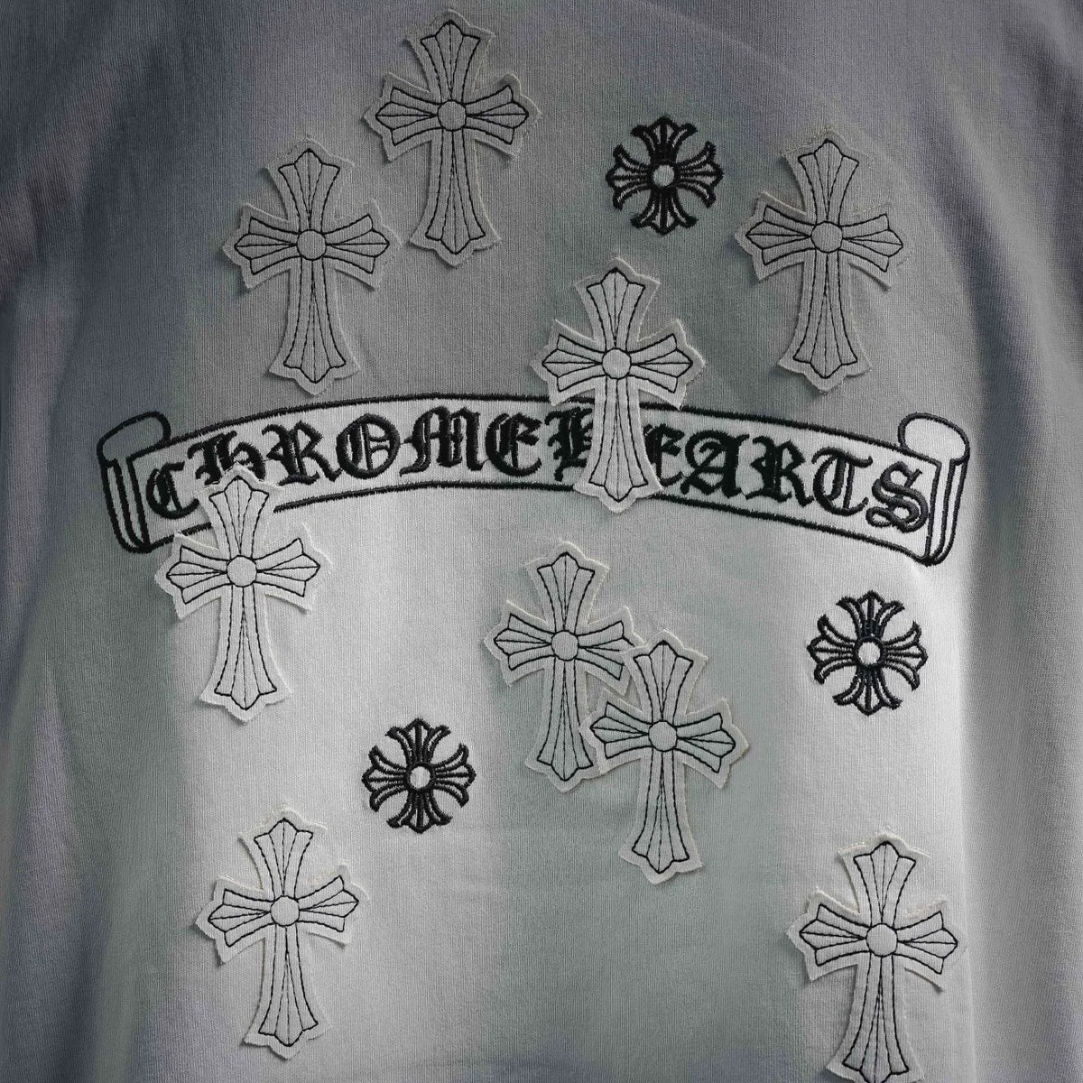 White T-shirt front with embroidered “Chrome Hearts” text and multiple cross icons