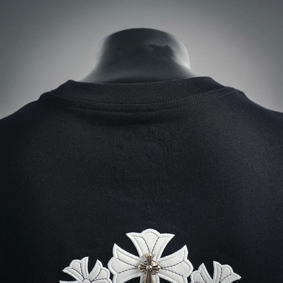 Black crewneck T-shirt back collar with white cross applique detail