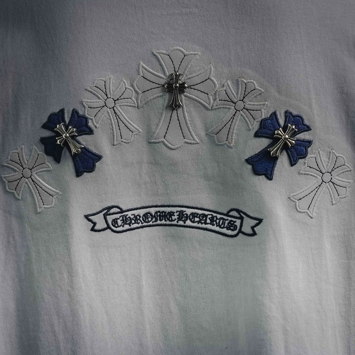Close-up of T-shirt back embroidery: bows and ribbon-style logo