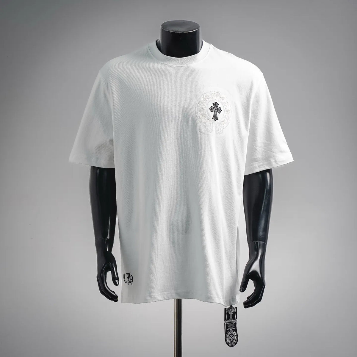 White short-sleeve T-shirt with small embroidered cross emblem on the chest