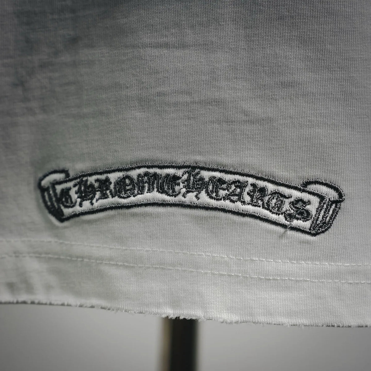 Close-up of white T-shirt patch logo label near hem