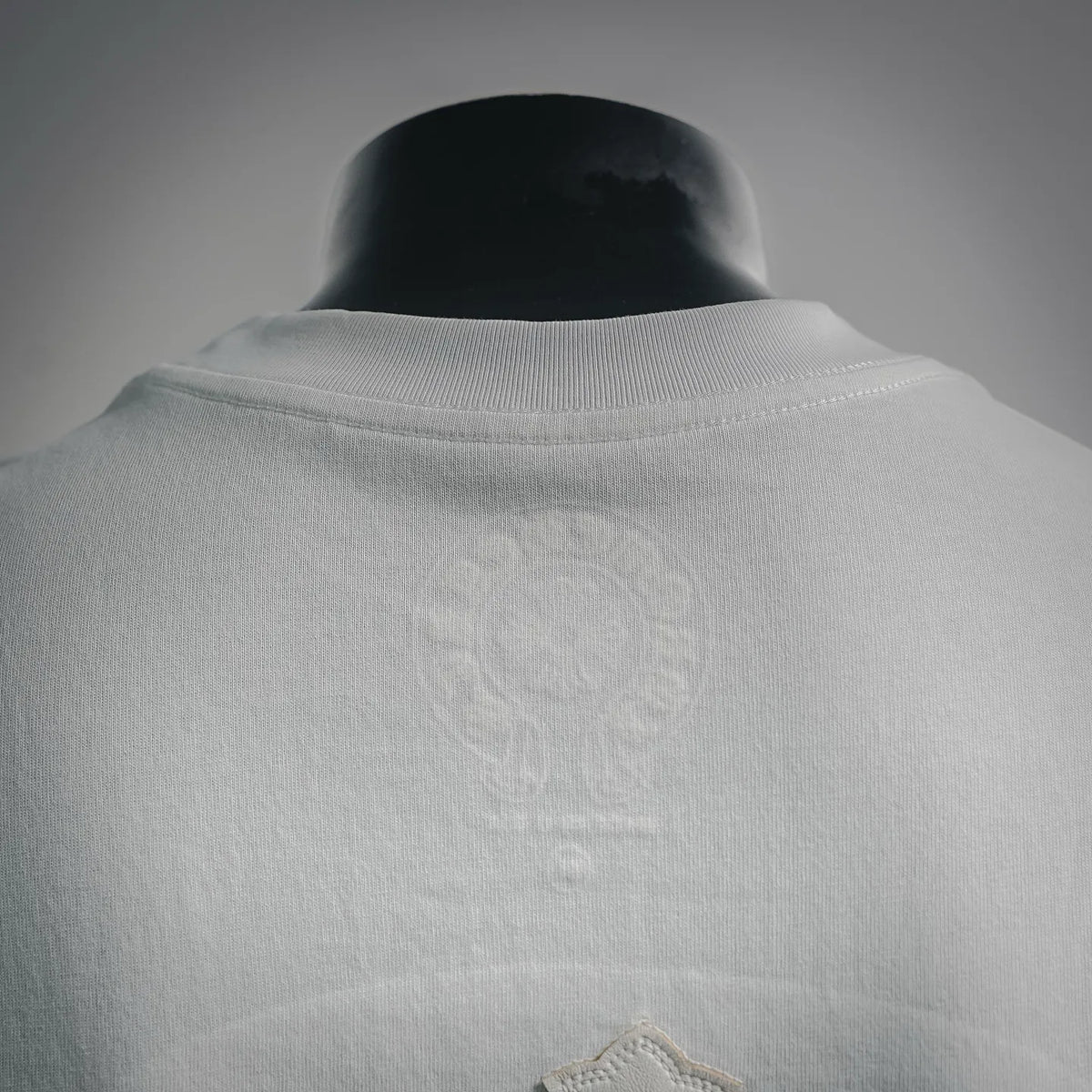 White T-shirt neckline and upper back with subtle logo embroidery
