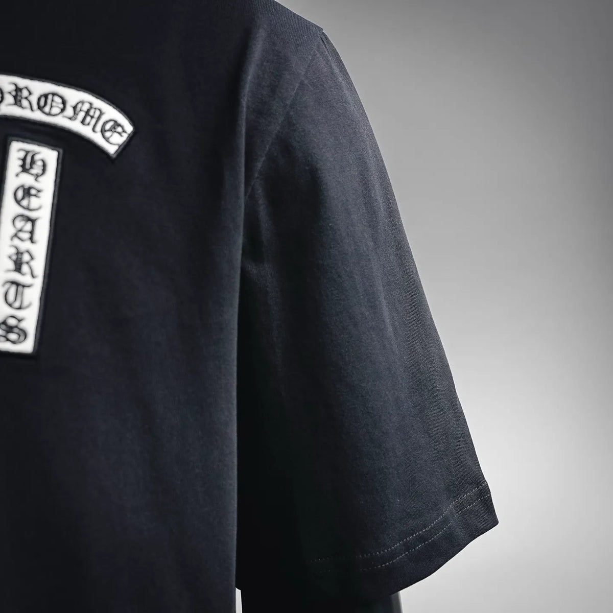 Black short-sleeve T-shirt with vertical logo label on chest
