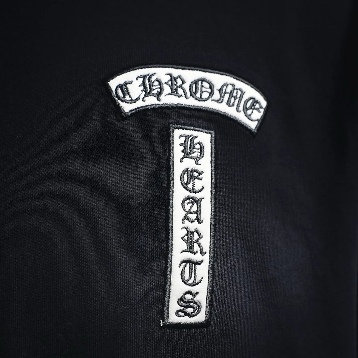 Black T-shirt with embroidered brand logo patch and vertical emblem