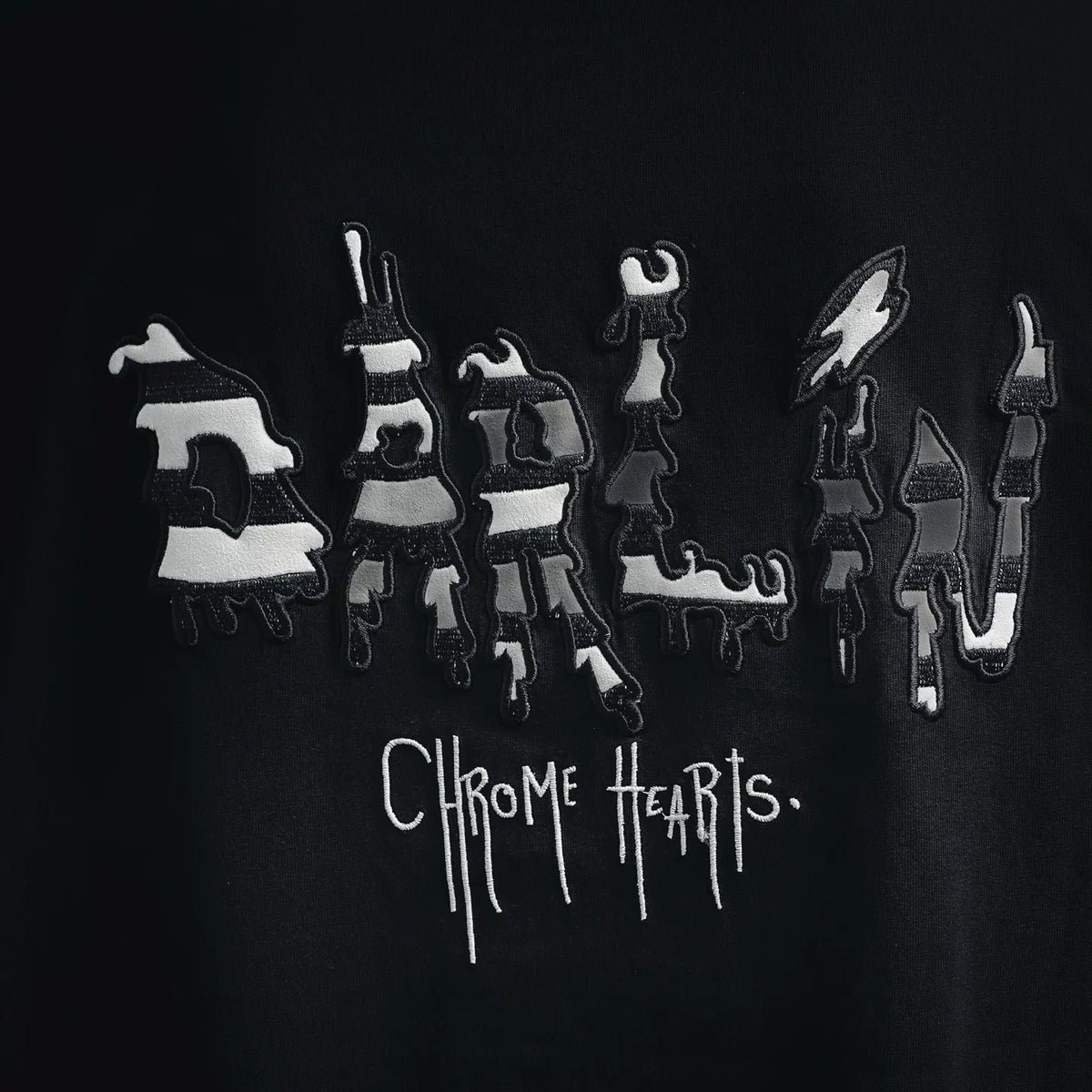 Black T-shirt with large front graphic of figures and dripping “Chrome Hearts” text