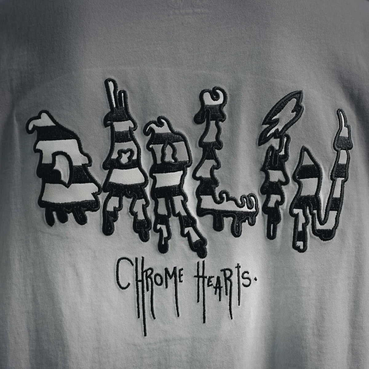 White T-shirt close-up of front character lineup graphic with dripping text