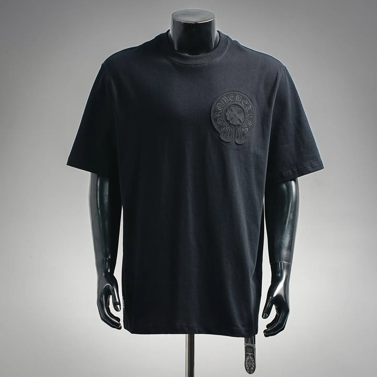 Black short-sleeve T-shirt with small chest logo patch