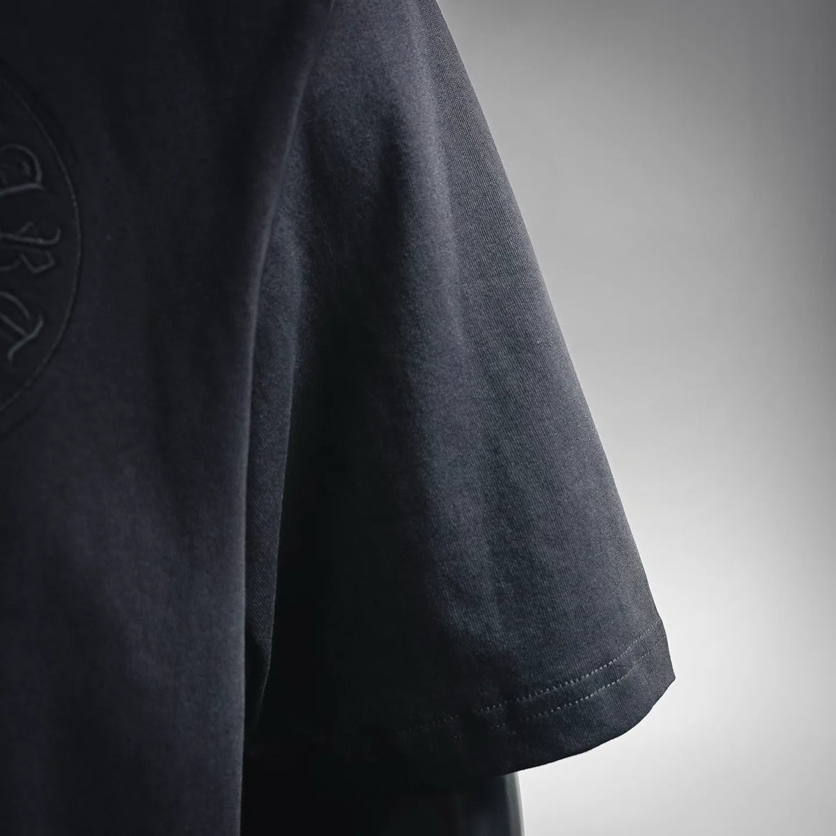 Black short-sleeve T-shirt sleeve with stitched hem and slight drape