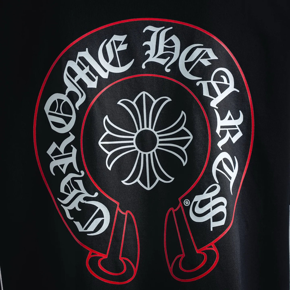 Back emblem graphic on black T-shirt with red outline and white flower center