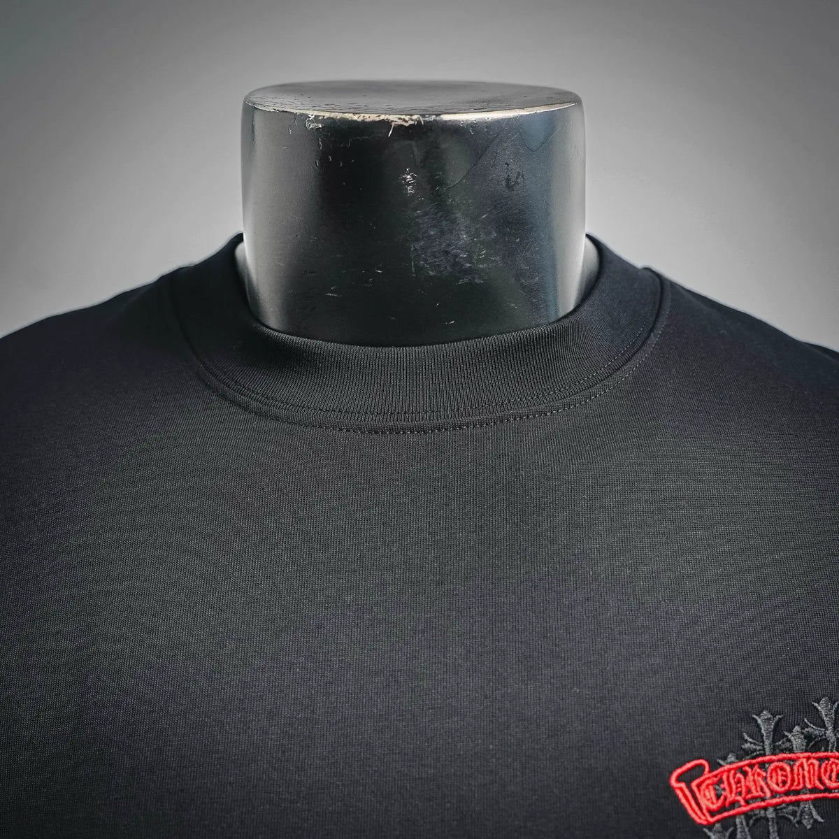 Black short-sleeve T-shirt neckline and small red corner logo