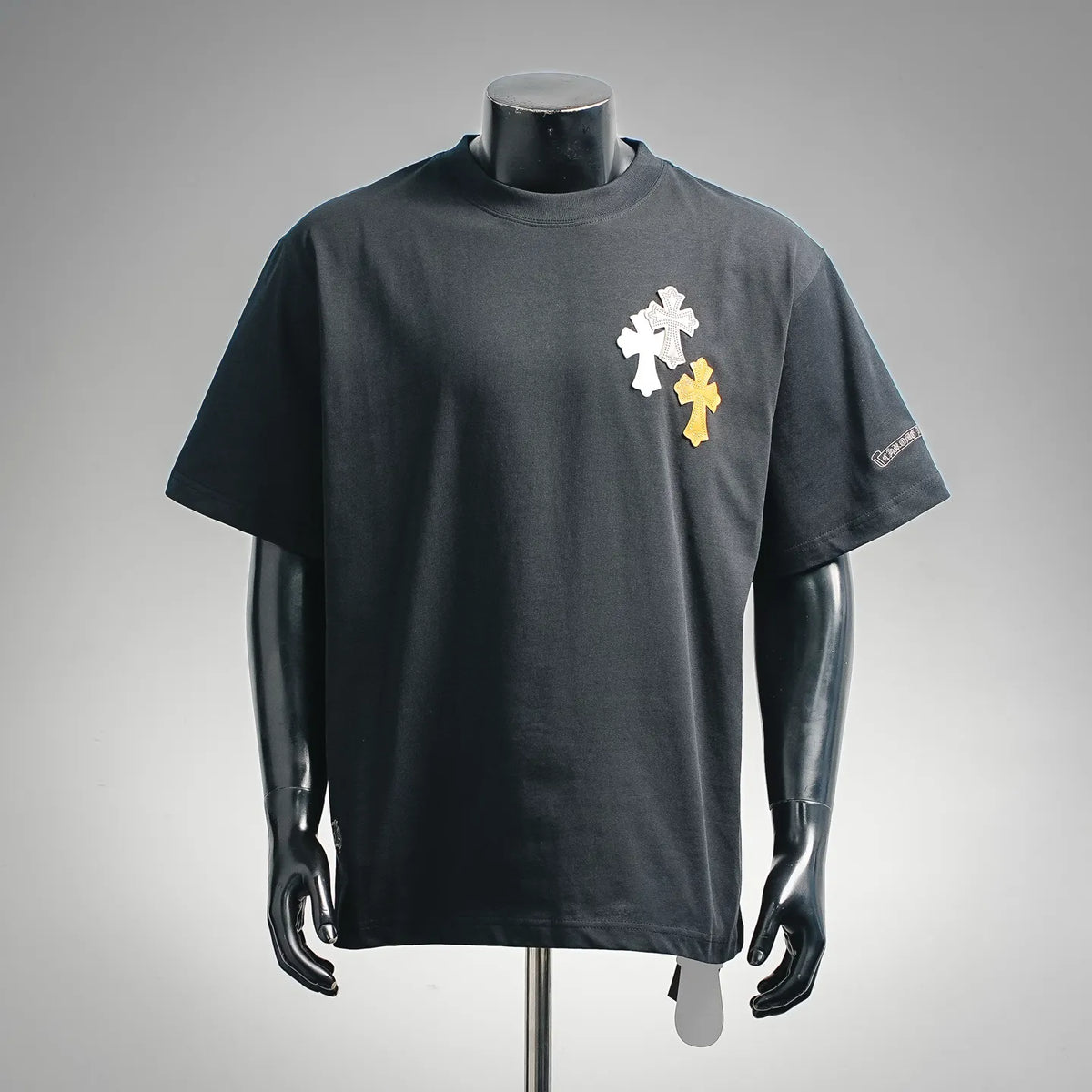 Dark short-sleeve T-shirt with vertical cross applique in white and gold on chest