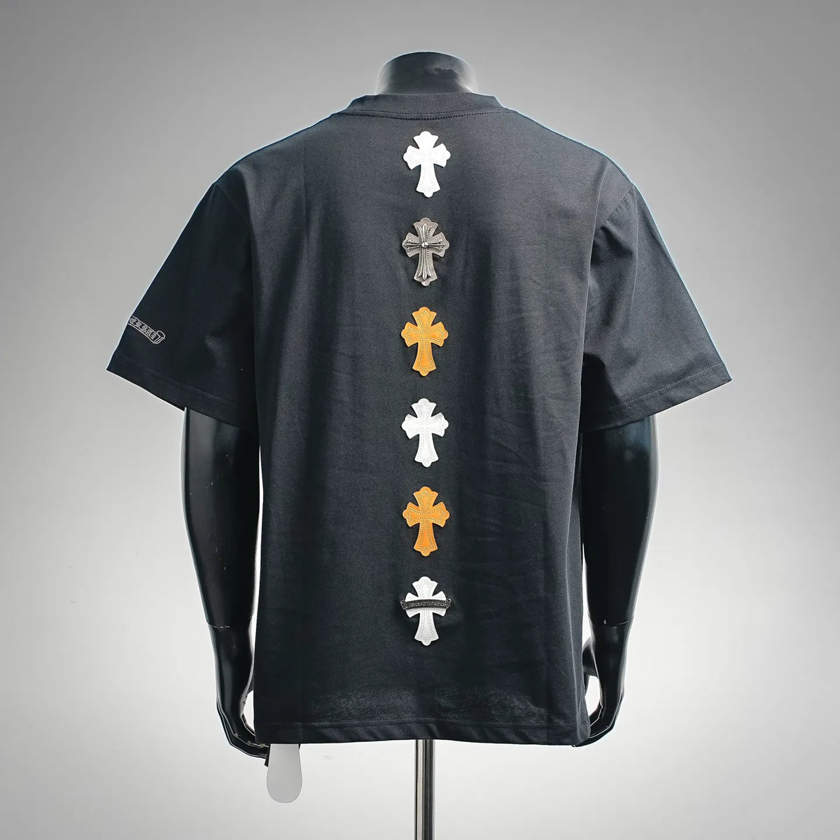 Dark short-sleeve T-shirt with column of cross applique on back in white and gold