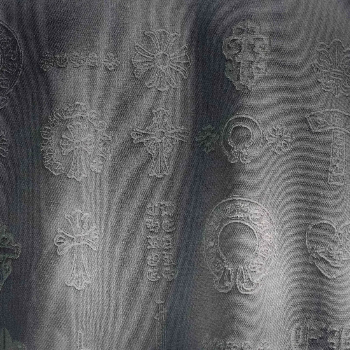 Embossed decorative icon pattern on white T-shirt fabric close-up
