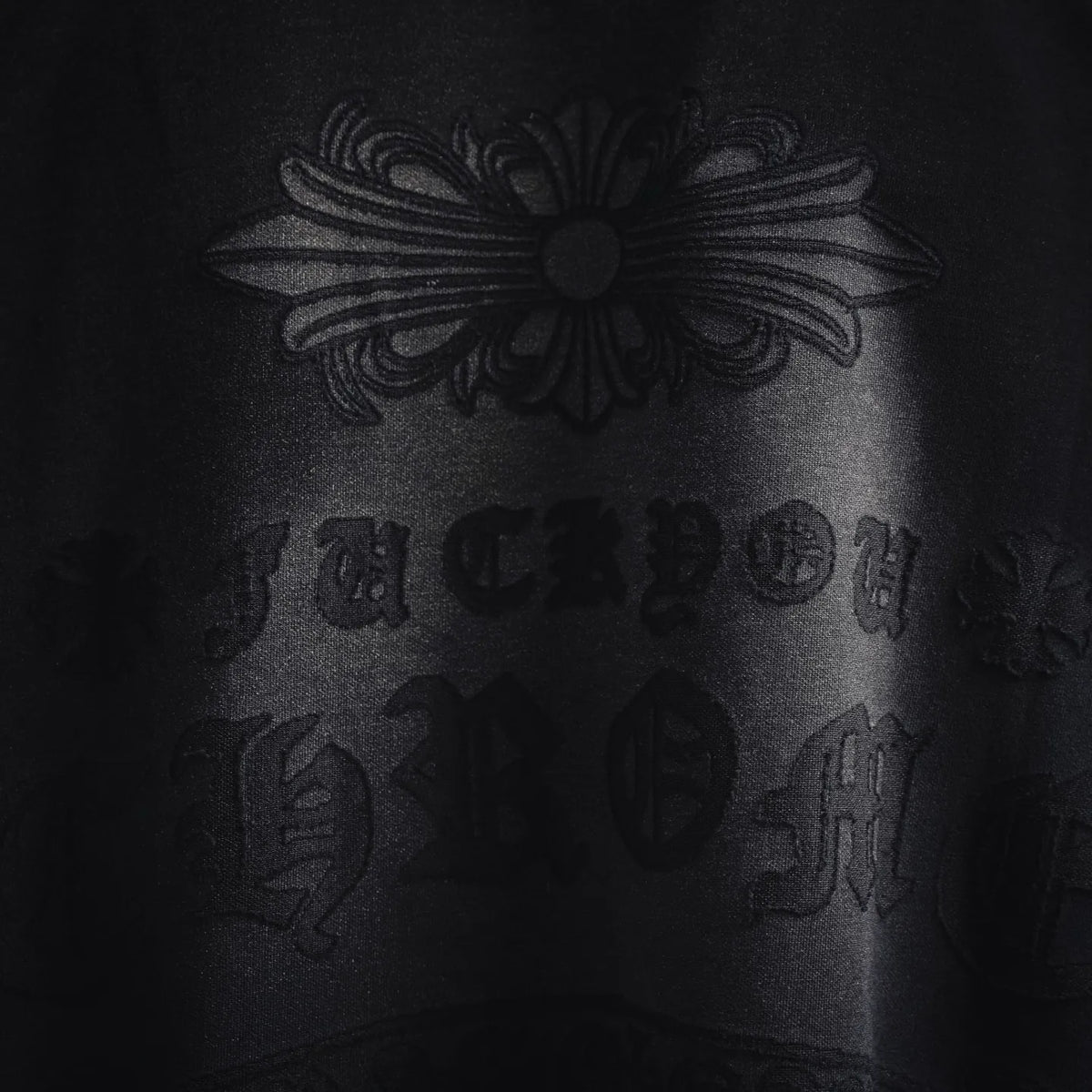 Black T-shirt back graphic with floral emblem and embossed-style lettering