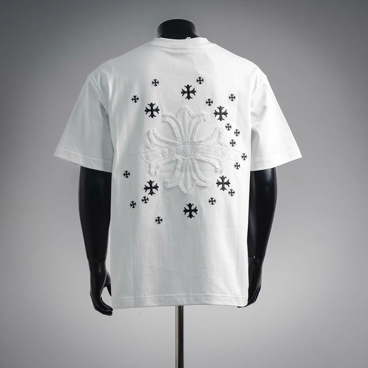 White short-sleeve T-shirt with large back embroidered crest and scattered black snowflake motifs