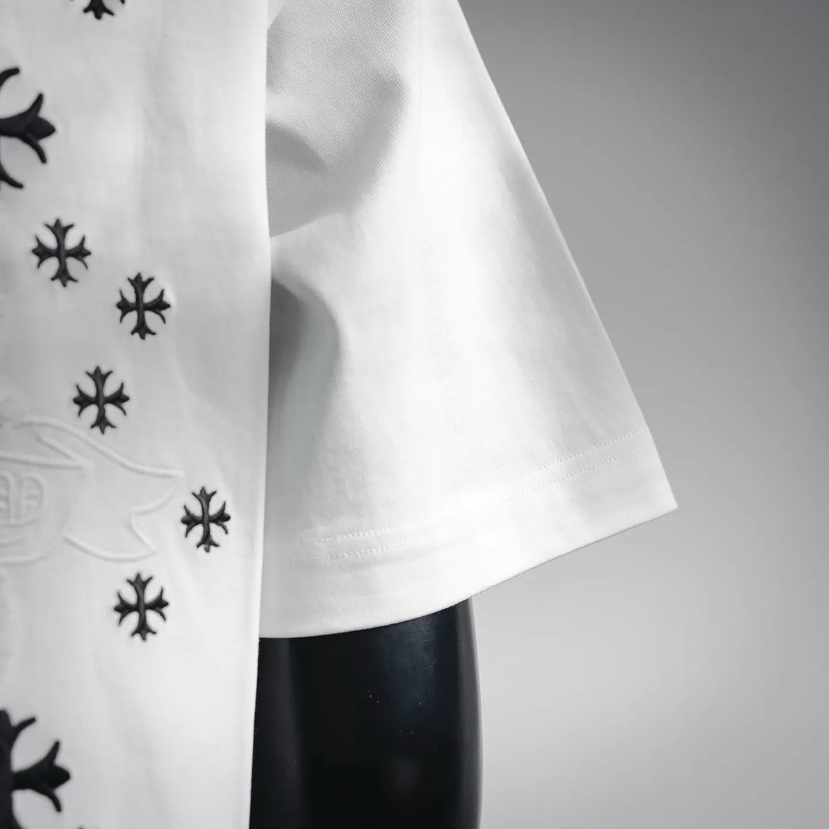 White short-sleeve T-shirt side view with black snowflake motifs and curved hemline