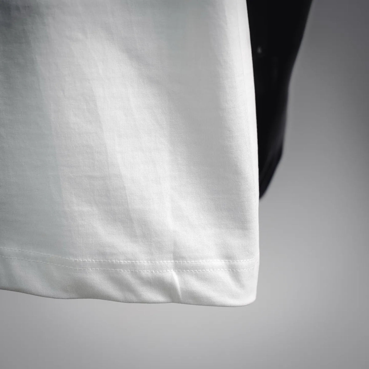 White T-shirt hem corner with visible stitching