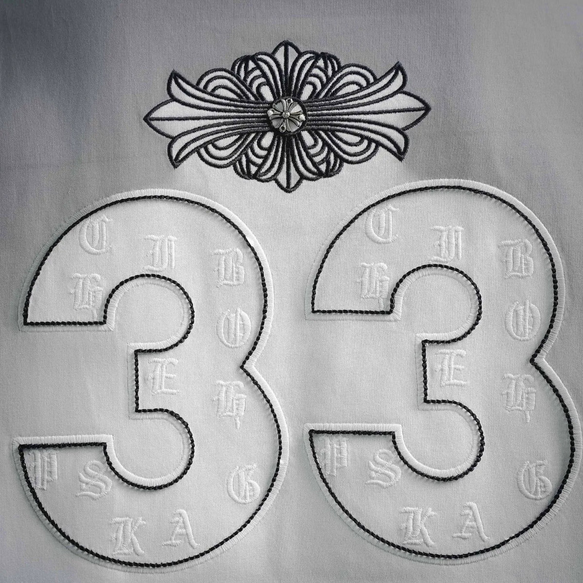 White T-shirt front graphic close-up: large 33 with flower at top
