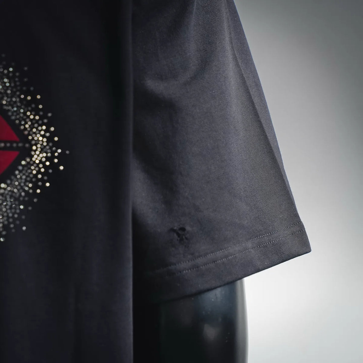 Black short-sleeve T-shirt with rhinestone logo and sleeve hem detail
