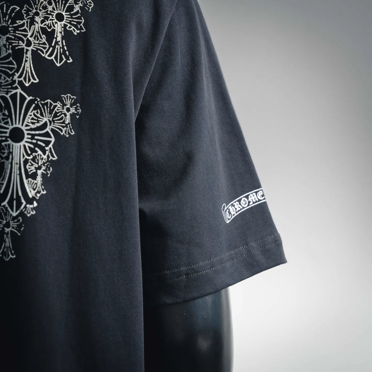 Black short-sleeve T-shirt with white sleeve logo patch near cuff