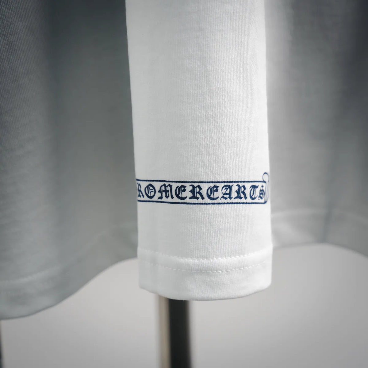 White T-shirt hem with stitched logo band near the bottom edge