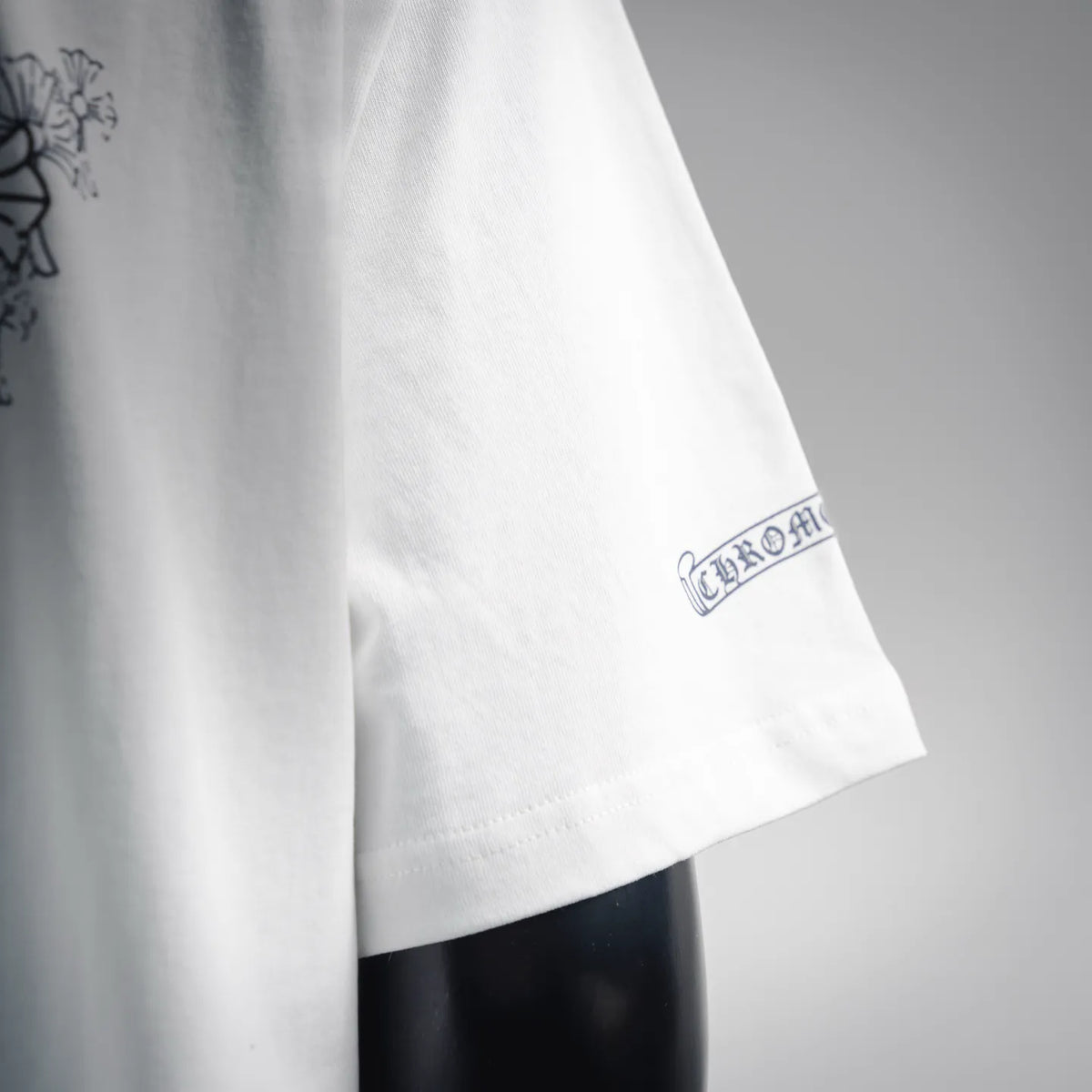 White T-shirt with small oval logo at the sleeve cuff
