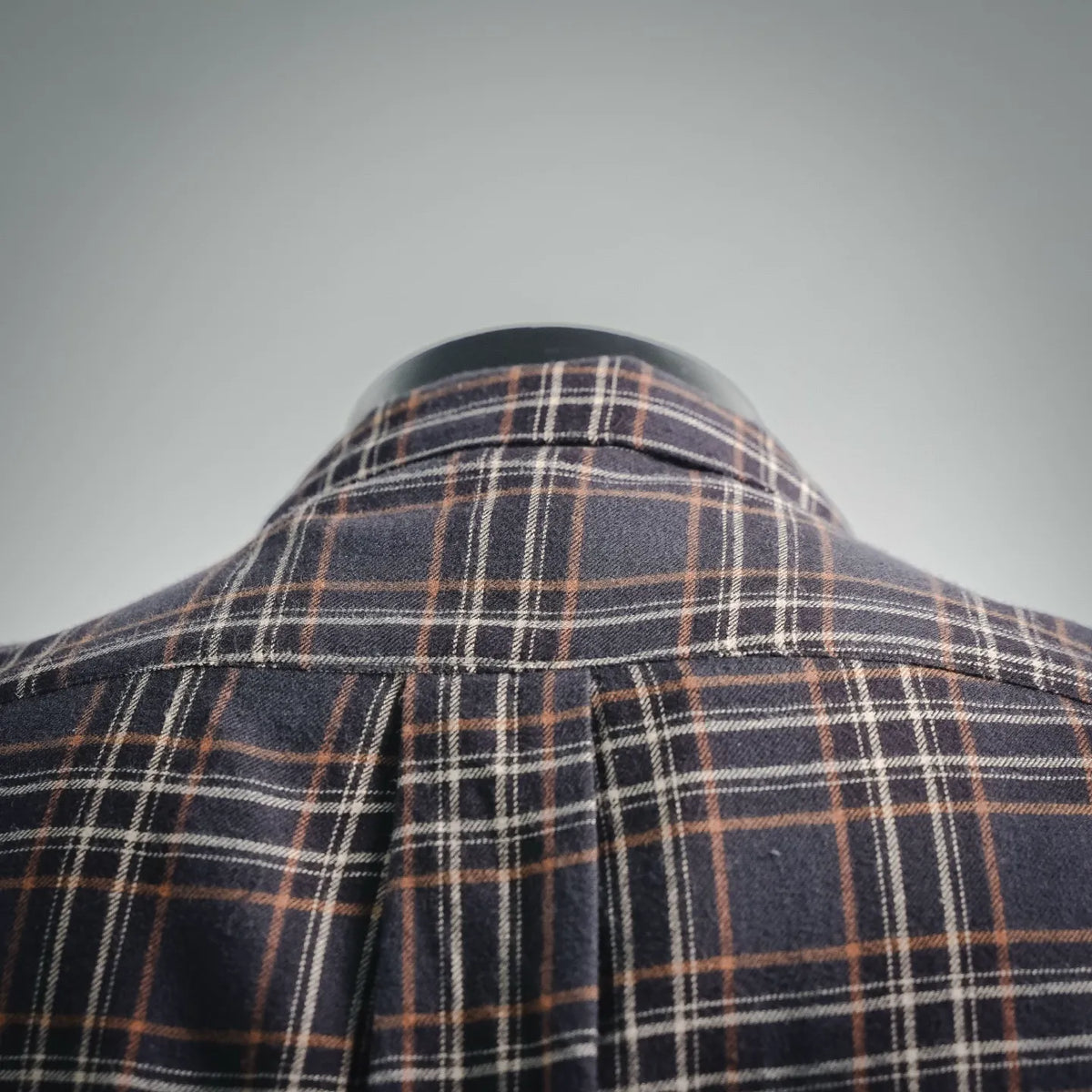 Plaid shirt collar and yoke close-up, dark checks with tan and orange stripes