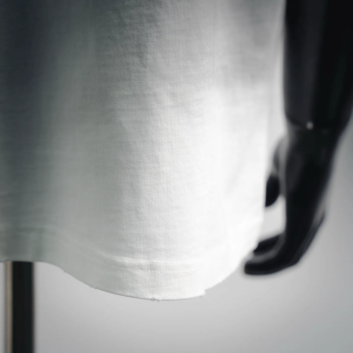 White T-shirt fabric with visible stitching on the lower hem