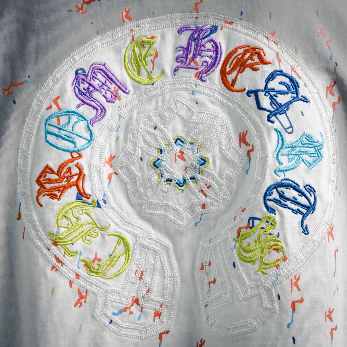 Close-up of circular multicolor embroidered design on a white T-shirt