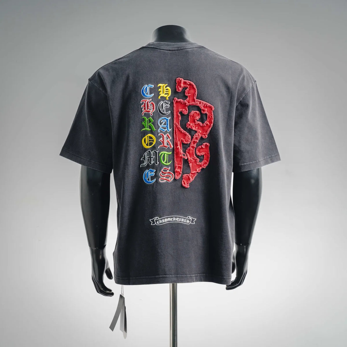 Dark charcoal crew-neck t-shirt with large multicolor embroidered back graphic.