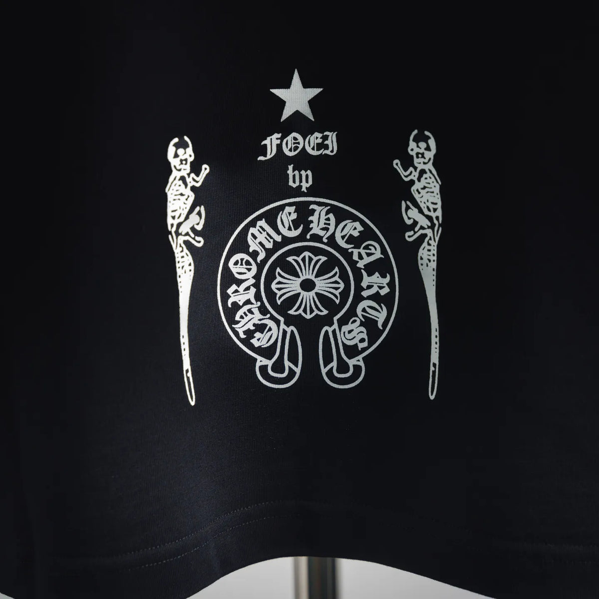 Black T-shirt back close-up of white graphic emblem with star above