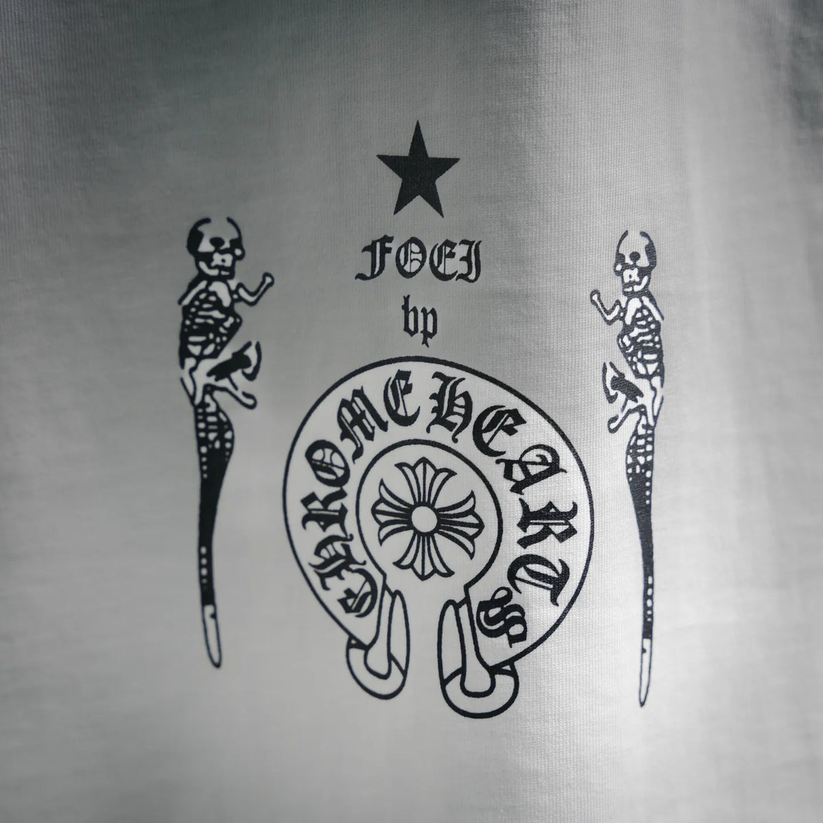 Close-up of black-and-white skull graphic with stars and figures on T-shirt