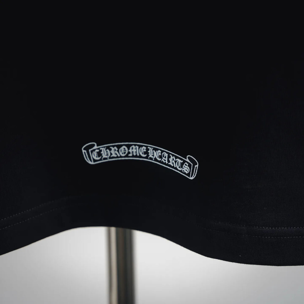 Black T-shirt collar label with white embroidered text