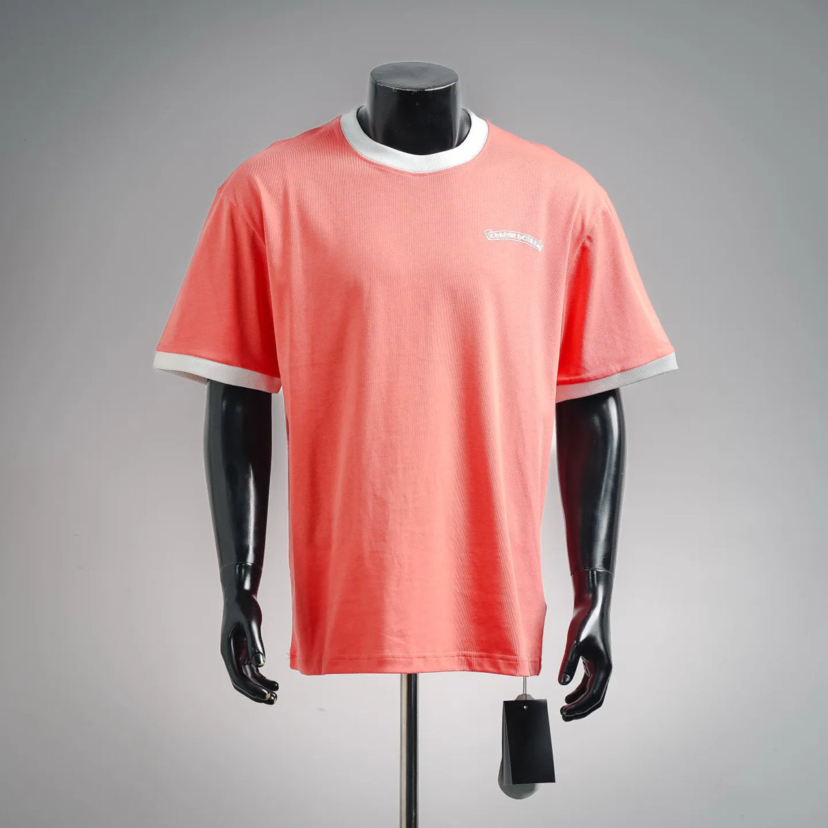 Coral pink short-sleeve graphic T-shirt with white crew neck trim and small chest logo