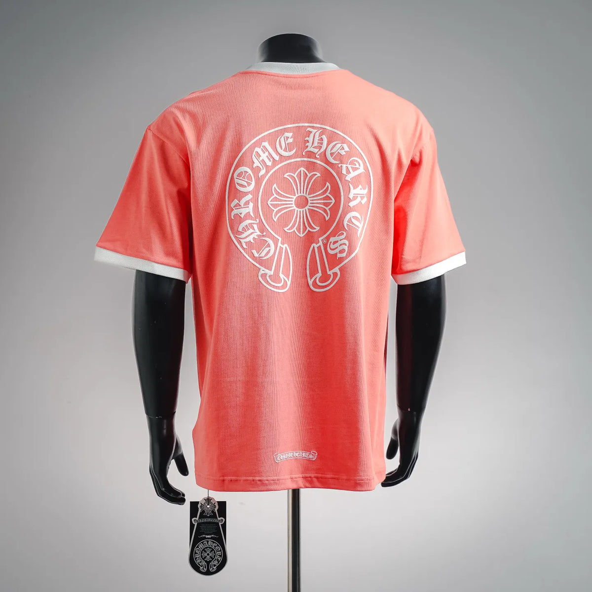 Coral pink short-sleeve graphic T-shirt with large back circular emblem and white collar trim