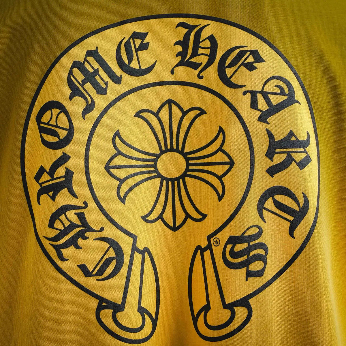 Yellow T-shirt back graphic with flower and curved lettering in black ink