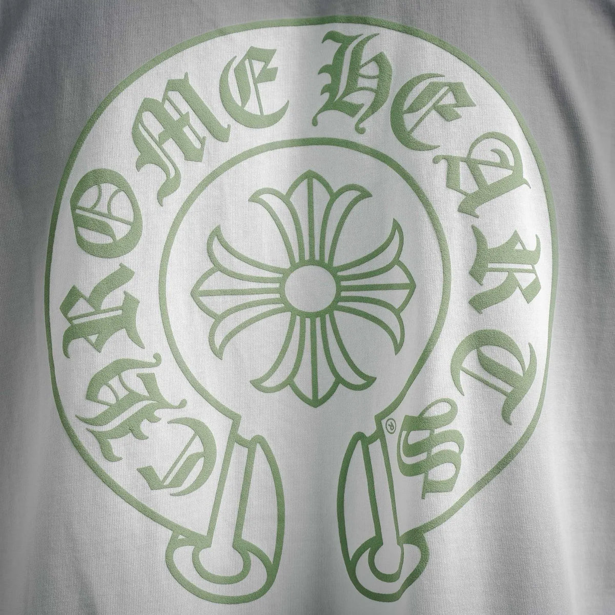 White T-shirt with large green flower emblem graphic on back