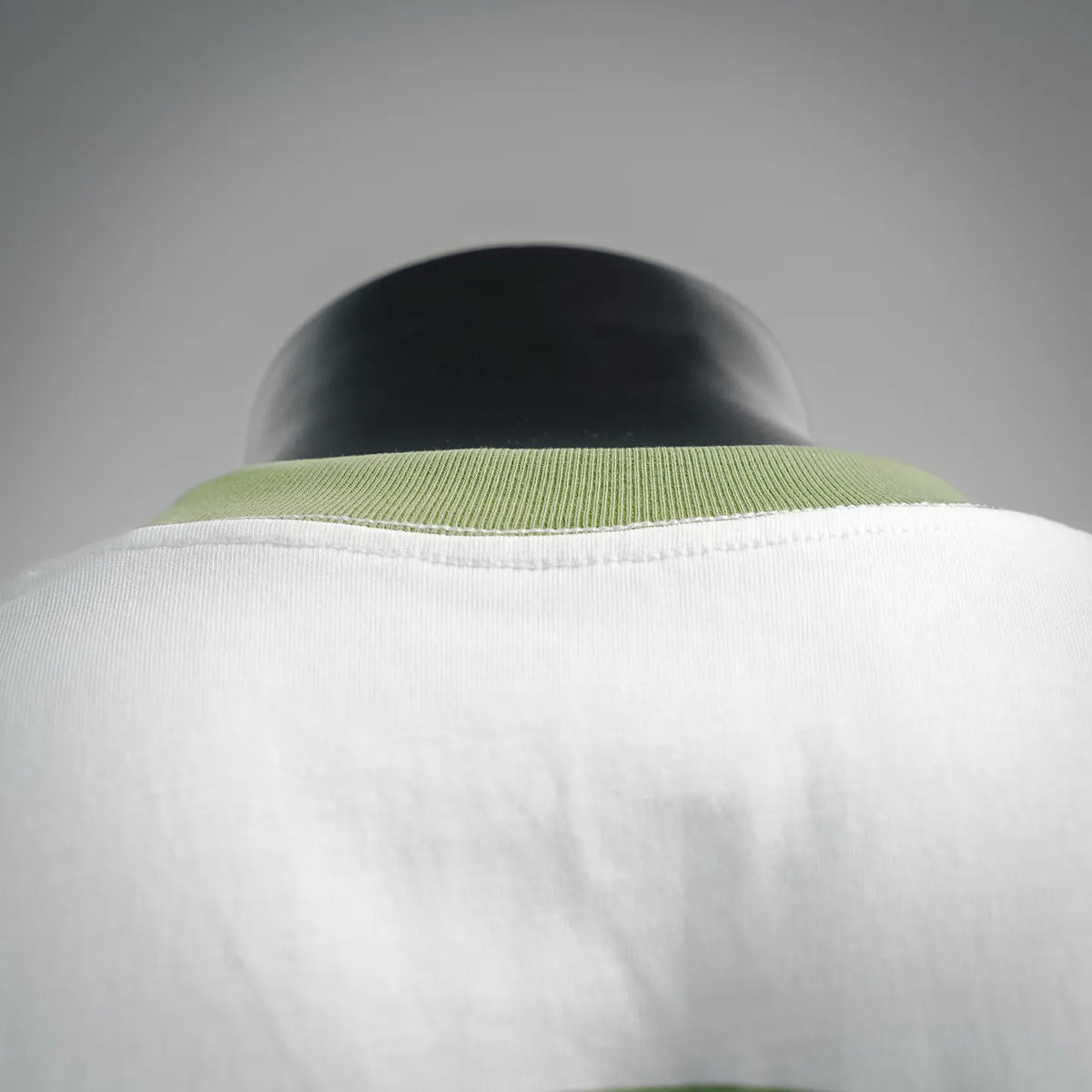White T-shirt with green ribbed collar and neckline seam