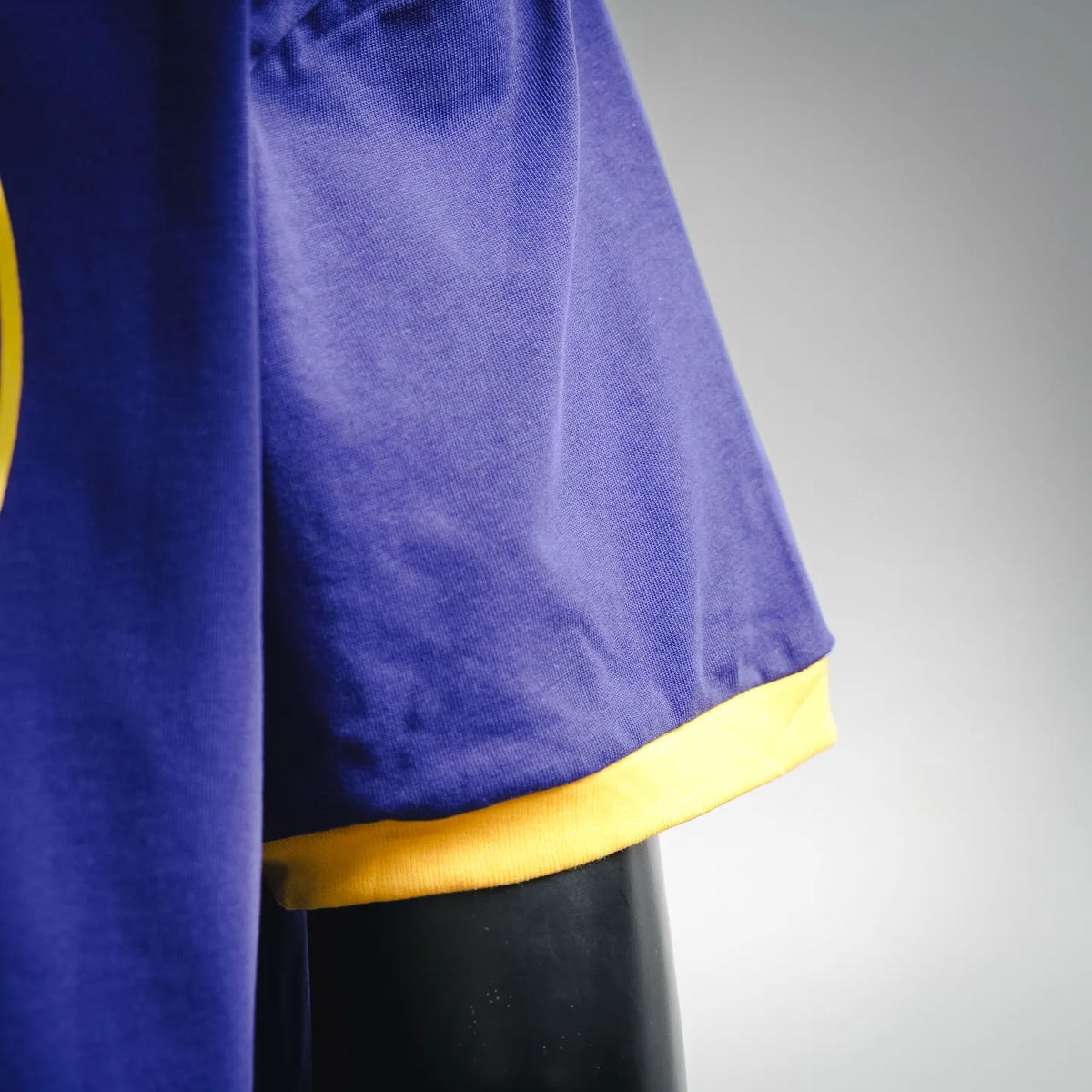 Royal blue T-shirt with yellow ribbed sleeve cuff and curved hem.