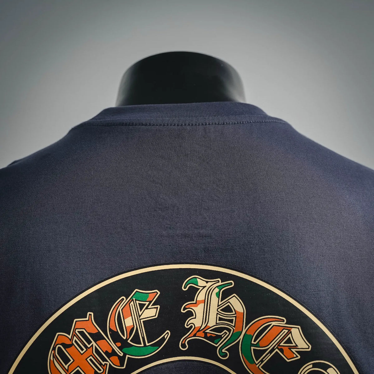 Close-up of dark navy T-shirt back neck area with top of circular graphic print