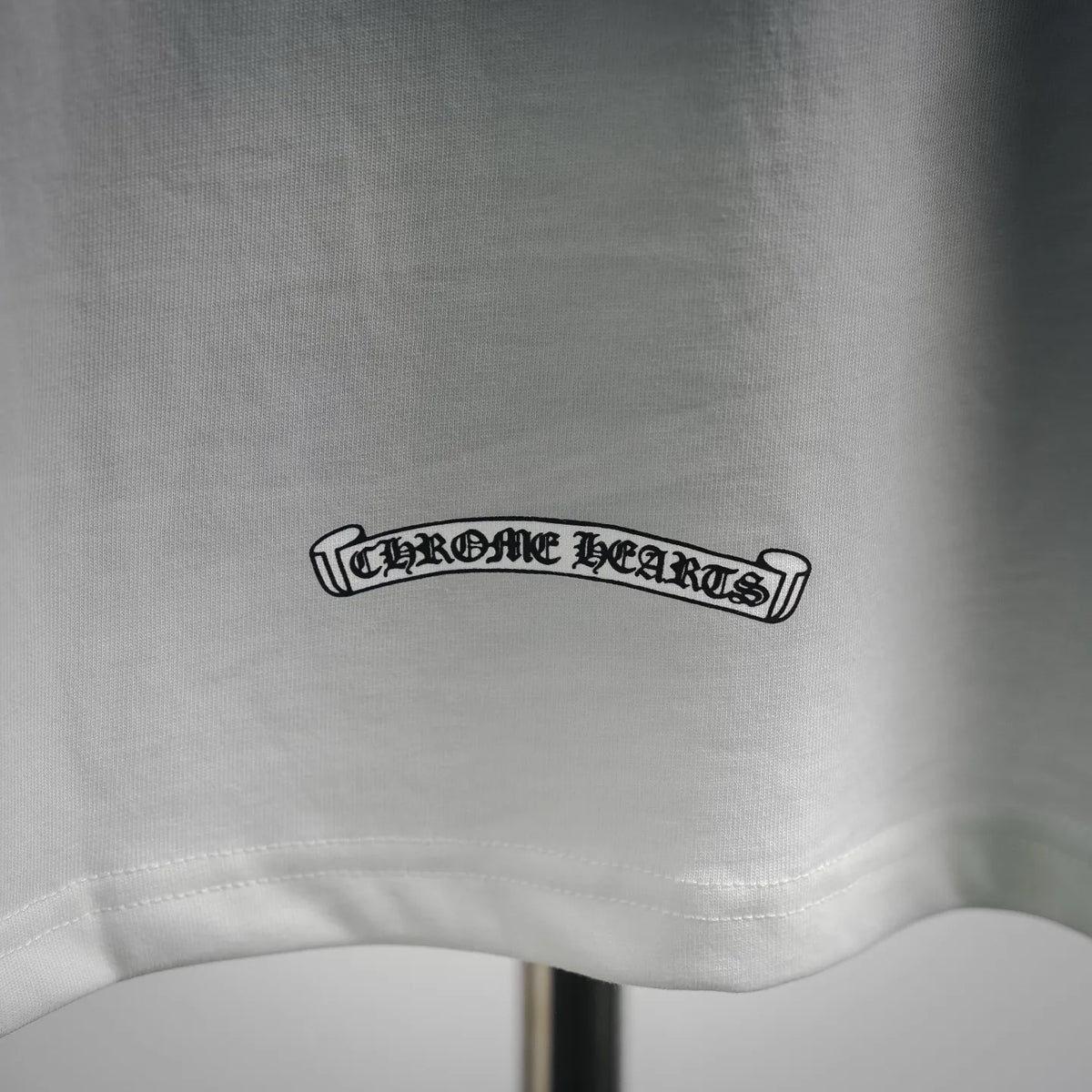 Close-up of white T-shirt hem with printed logo